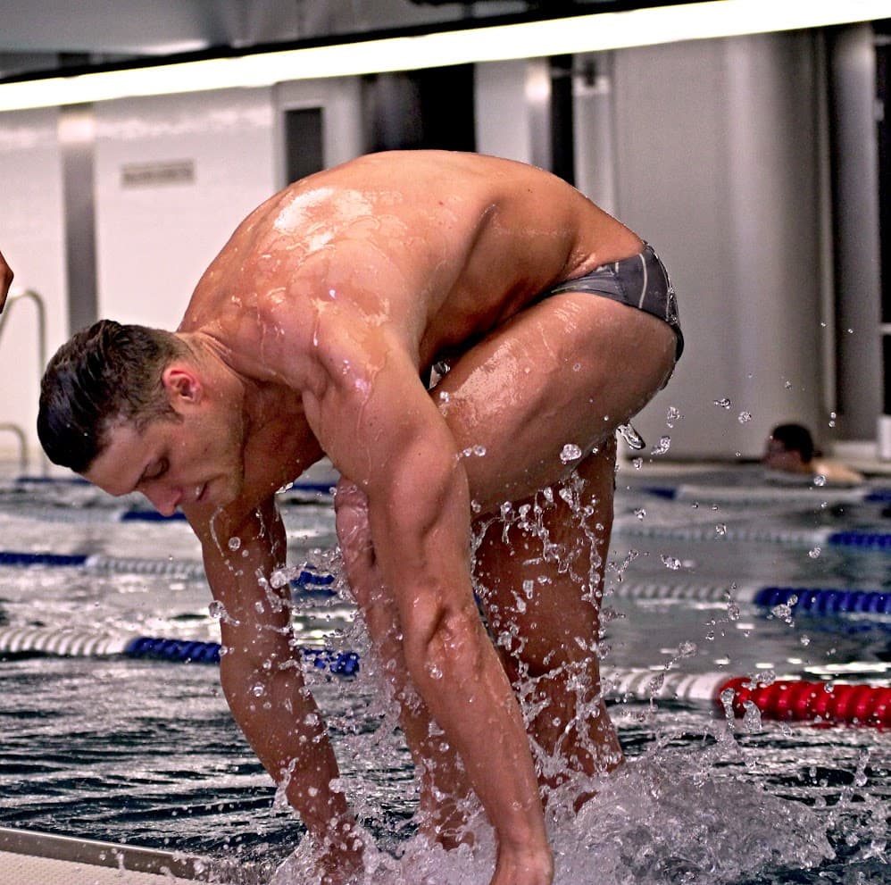 Plavec pri okraji bazéna počas intenzívneho tréningu vo vode